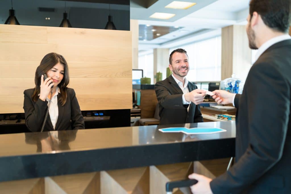 receptionist giving card key to businessman at lob 2025 06 08 09 03 53 utc 1